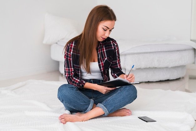 Domowy styl życia kobiety writing w łóżku