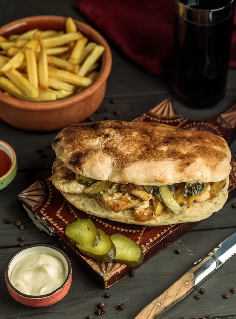 Doner z kurczaka w chlebie faszerowany marynowanym ogórkiem podany z frytkami