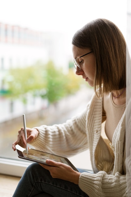 Bezpłatne zdjęcie dorosła ilustratorka pracująca na tablecie