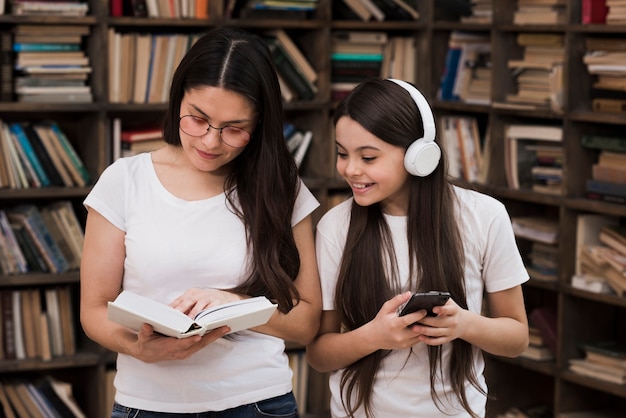 Dorosła kobieta i młoda dziewczyna razem w bibliotece