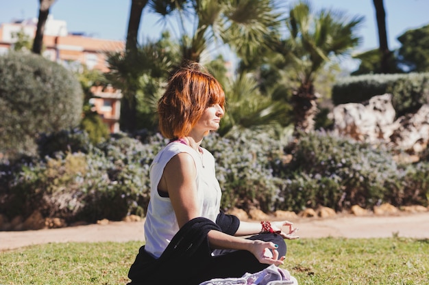 Dorosła kobieta medytuje w parku