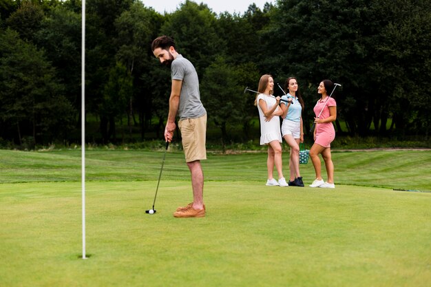 Dorosły sprawny człowiek trenuje golf na świeżym powietrzu