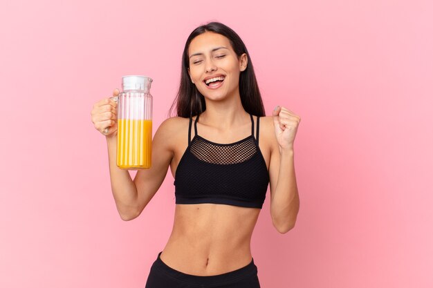 Dość hiszpańska kobieta fitness z sokiem pomarańczowym