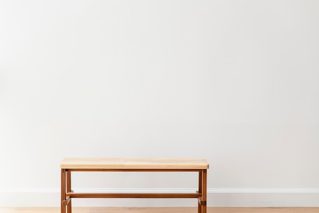 Drewniana ławka przy białej ścianie