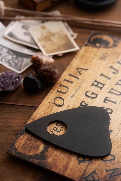 Drewniana tablica ouija i stare zdjęcia pod dużym kątem