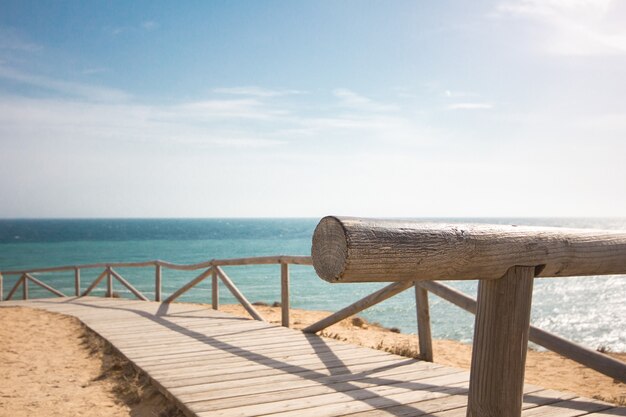 Drewniany chodnik z poręczami wzdłuż plaży w ciągu dnia