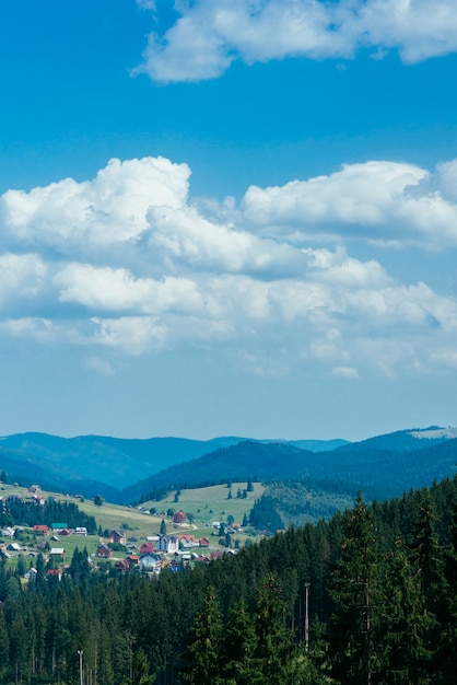 Drewniany dom w zielonych górach z niebieskim niebem i chmurami