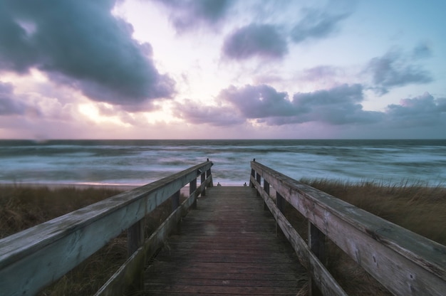 Bezpłatne zdjęcie drewniany taras na plaży otoczonej morzem na wyspie sylt w niemczech