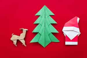 Bezpłatne zdjęcie drzewko świąteczne; renifer; origami papieru świętego mikołaja na czerwonym tle