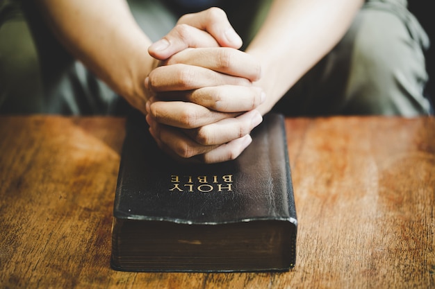 Duchowość I Religia, Ręce Złożone Do Modlitwy Na świętą Biblię W Kościelnym Pojęciu Wiary.