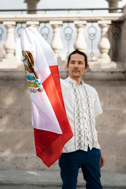 Bezpłatne zdjęcie dumny mężczyzna noszący meksykańską flagę z przodu