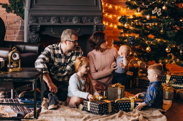 Duża rodzina w Wigilię Bożego Narodzenia z prezentami przy choince