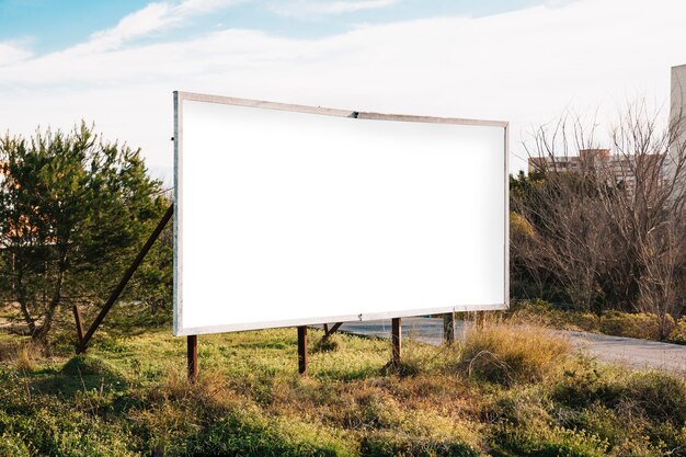 Duży biały billboard na zielonym poboczu