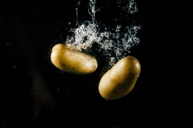 Dwa duże ziemniaki wpadają do wody i tworzą baniek