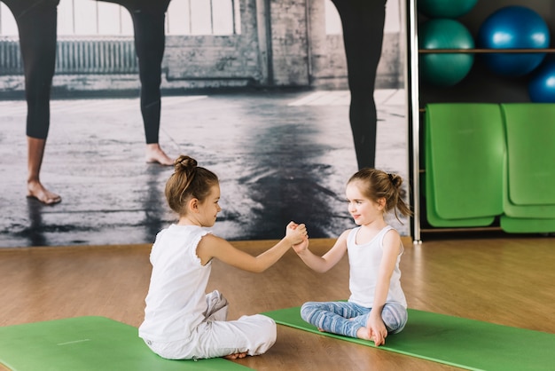 Dwa Dziewczyn Dziecka Obsiadanie Na Joga Macie I Bawić Się W Gym