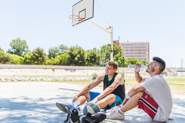 Dwa gracz koszykówki relaksuje przy outdoors sądem