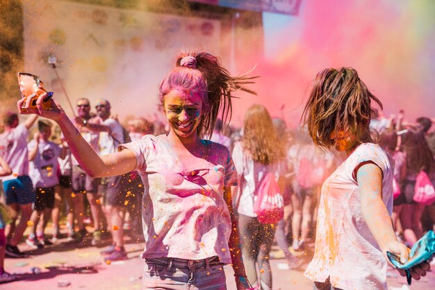 Dwa młodej kobiety bawić się i cieszy się z holi kolorami