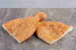 Bezpłatne zdjęcie dwa połówki bochenków chleba tandoori na marmurowym tle. zdjęcie wysokiej jakości