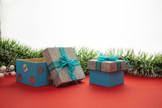 Dwa pudełka na prezenty z niebiesko-zieloną kokardką i białym konfo