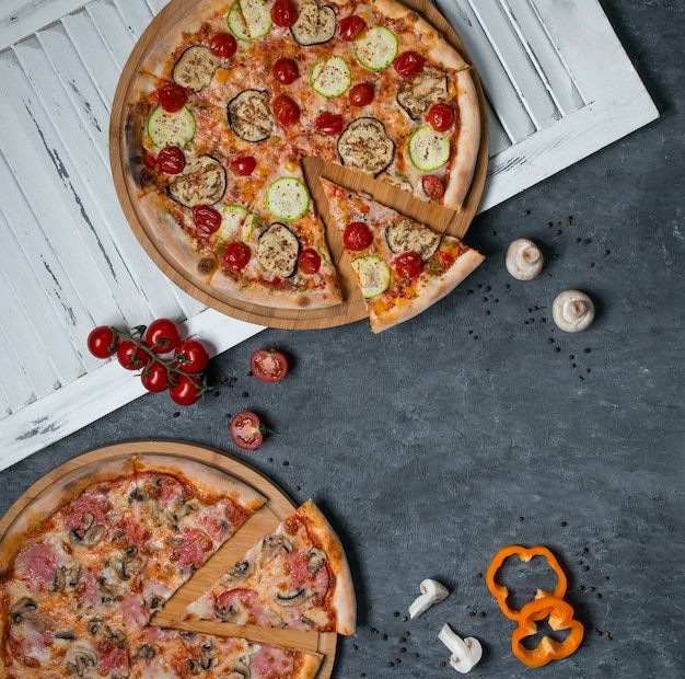 Dwa rodzaje pizzy z mieszanymi składnikami