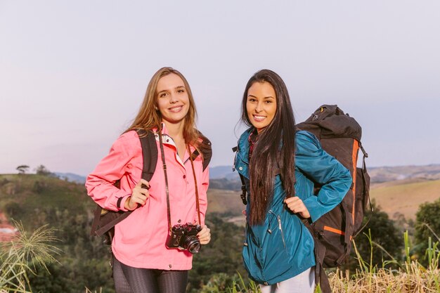 Dwa szczęśliwy młody żeński podróżnik z plecakiem i kamerą
