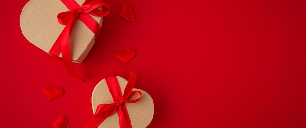 Dwa zapakowane pudełka na prezenty w kształcie serca na czerwonym tle święty walentynki