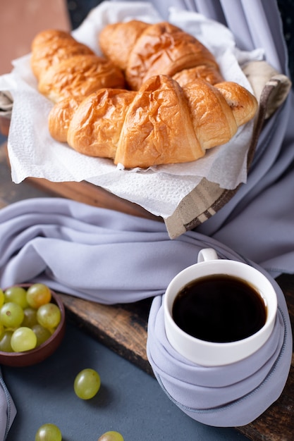 Dwie białe filiżanki herbatników cappucino i owsiane na niebieskim drewnianym stole.