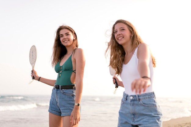 Bezpłatne zdjęcie dwie dziewczyny grać w tenisa na plaży w seashore