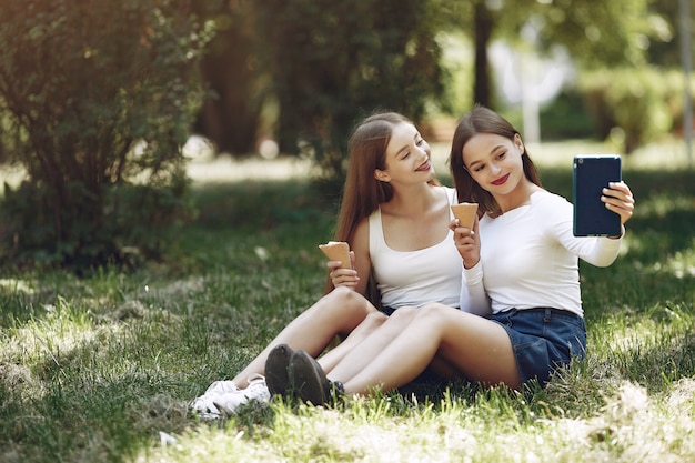 Dwie eleganckie i stylowe dziewczyny w wiosennym parku
