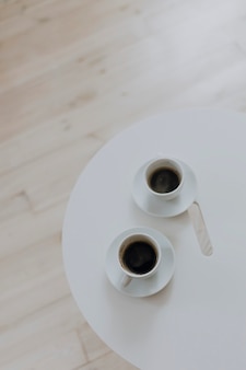 Dwie filiżanki kawy na białym stole
