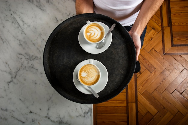 Bezpłatne zdjęcie dwie filiżanki kawy z latte art na tacy
