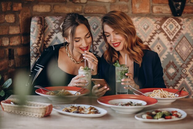 Dwie kobiety jedzą makaron we włoskiej restauracji