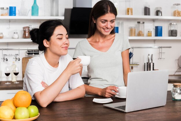 Dwie kobiety w kuchni w domu na czacie przy kawie
