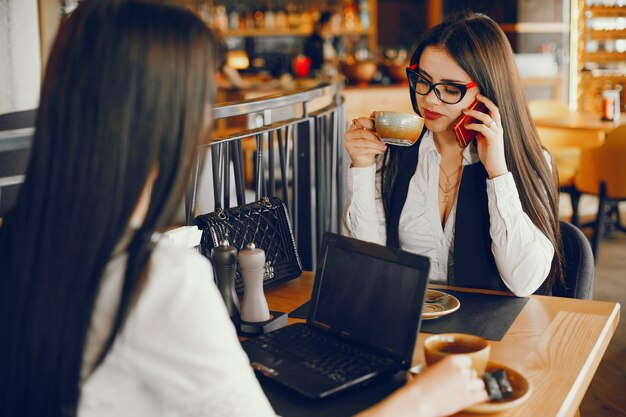 dwie luksusowe dziewczyny siedzą w restauracji