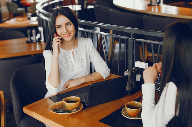 dwie luksusowe dziewczyny siedzą w restauracji