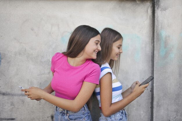 dwie młode dziewczyny używają smartfona