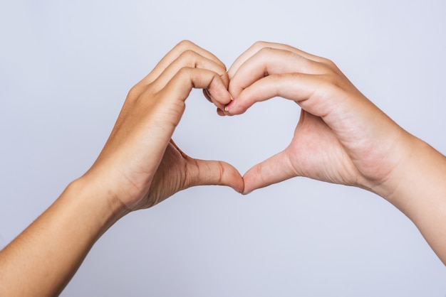 Dwie młode kobiety kochają się ręcznie znak w kształcie serca.