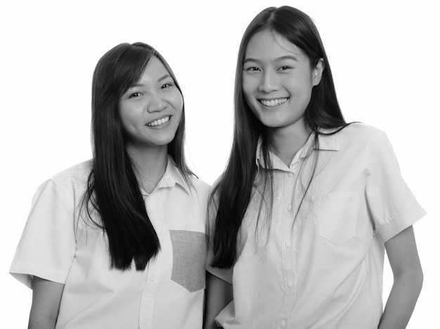 Dwie młode piękne azjatyckie nastolatki razem na białym tle. czarno-białe zdjęcie