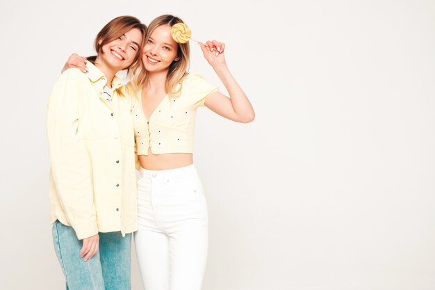 Dwie młode piękne blond uśmiechnięte hipsterki w modnych letnich ubraniach