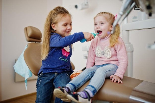 Dwie śliczne dziewczynki na fotelu dentystycznym Dzieci dentystyczne