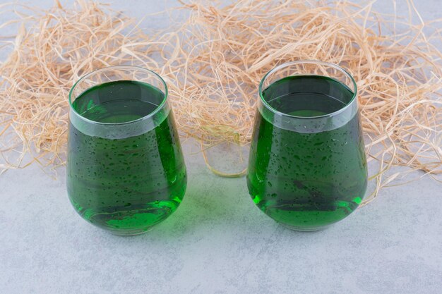 Dwie szklanki soku z estragonu na marmurowym tle. Zdjęcie wysokiej jakości