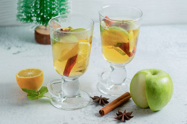 Dwie szklanki świeżego koktajlu jabłkowego ze świeżym jabłkiem i cytryną.