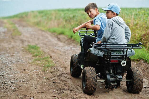 Dwóch braci jeżdżących czterokołowym quadem ATV Szczęśliwe chwile dla dzieci