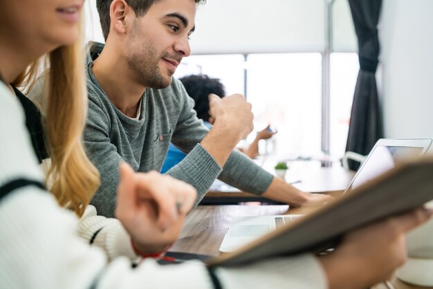 Dwóch kreatywnych projektantów pracujących razem nad projektem, czytając coś na tablecie cyfrowym i dzieląc się nowymi pomysłami w miejscu pracy. Koncepcja pracy firmy i zespołu.