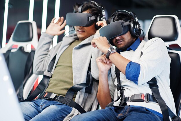 Dwóch młodych Hindusów bawi się z nową technologią zestawu słuchawkowego VR w symulatorze rzeczywistości wirtualnej