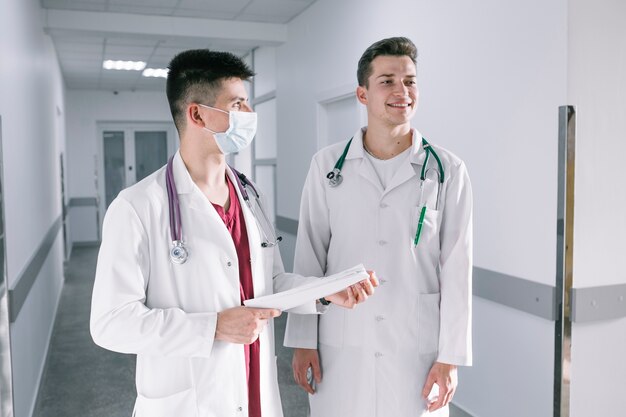 Dwóch młodych lekarzy stojących z dokumentami