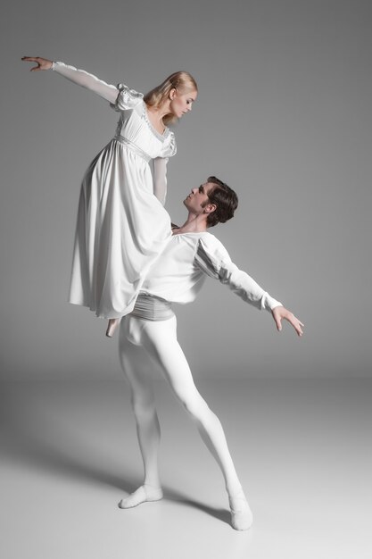 Dwóch młodych tancerzy baletowych ćwiczących. atrakcyjni wykonawcy tańca w bieli