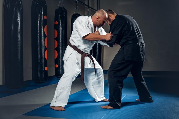 Dwóch zapaśników judo pokazujących swoje umiejętności techniczne w klubie walki.