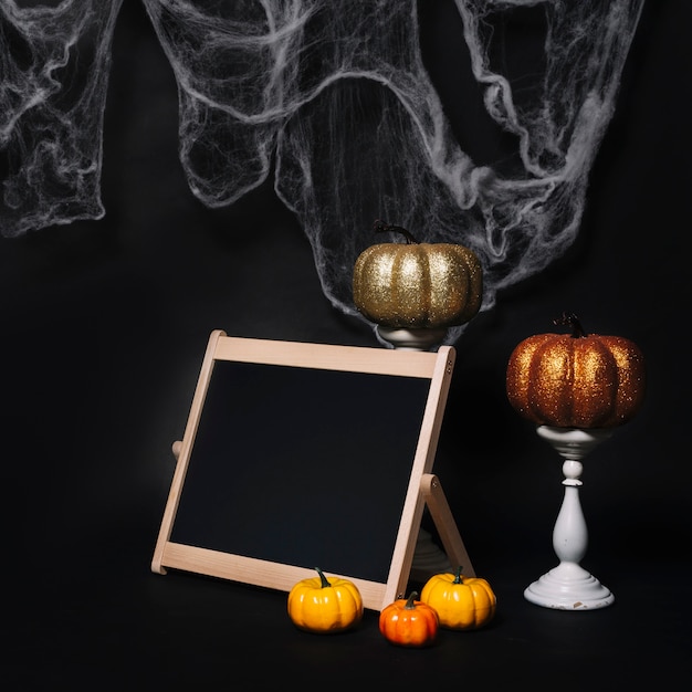 Bezpłatne zdjęcie dynie i tablica w pobliżu ozdoby halloween