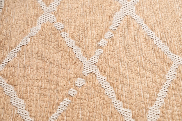 Bezpłatne zdjęcie dywan z beżowej, niestrzępiącej się bawełny z geometrycznym, dzianinowym wzorem w pionowe romby